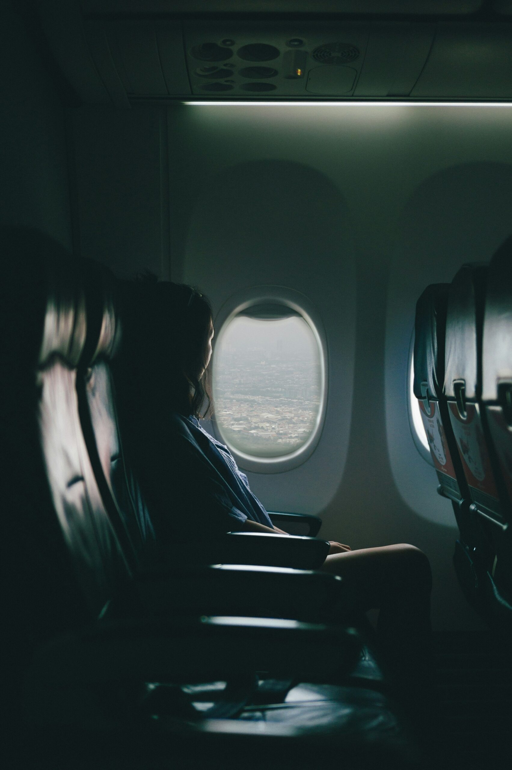 Female traveler stares out airplane window